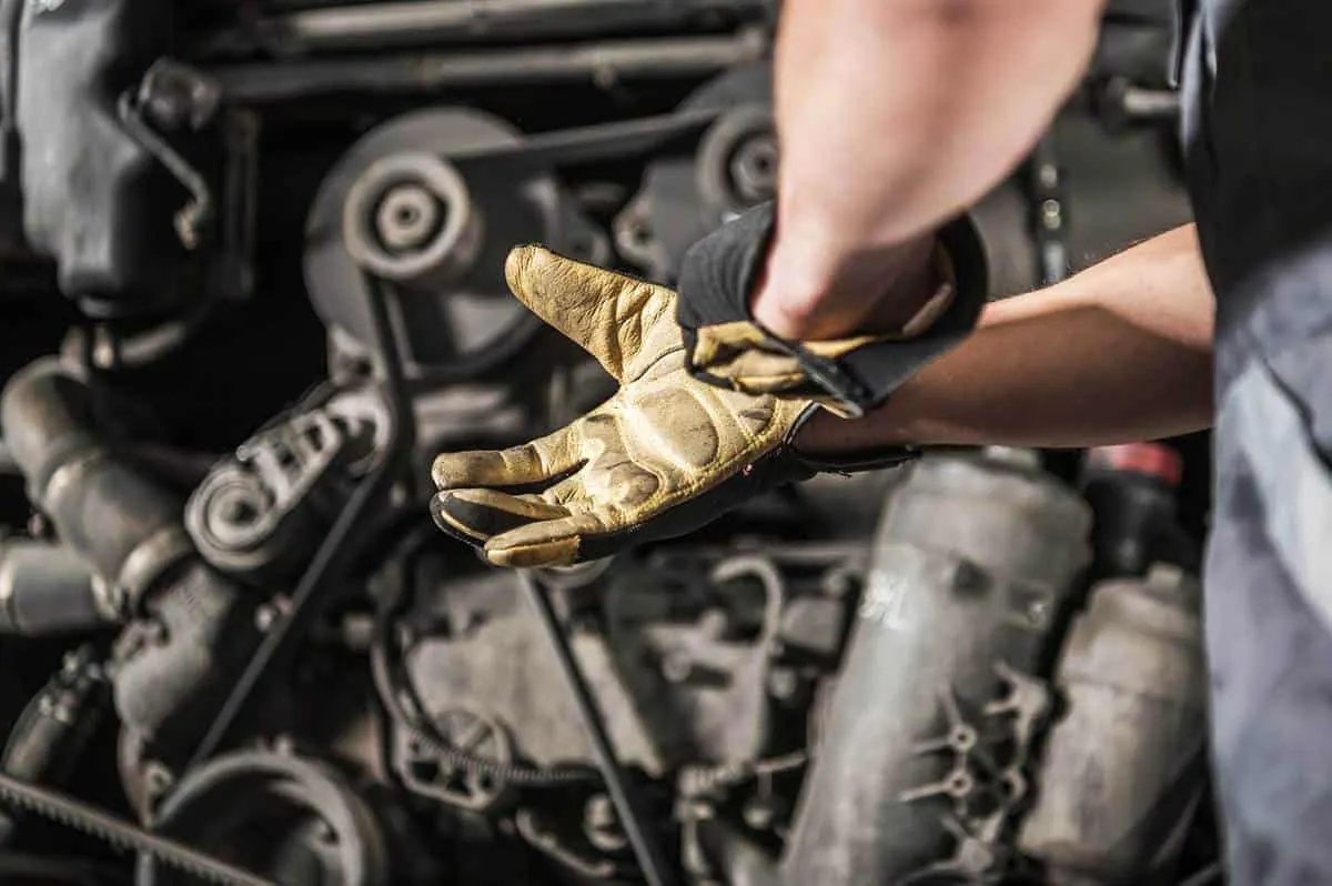 Gloved hand working on a diesel engine