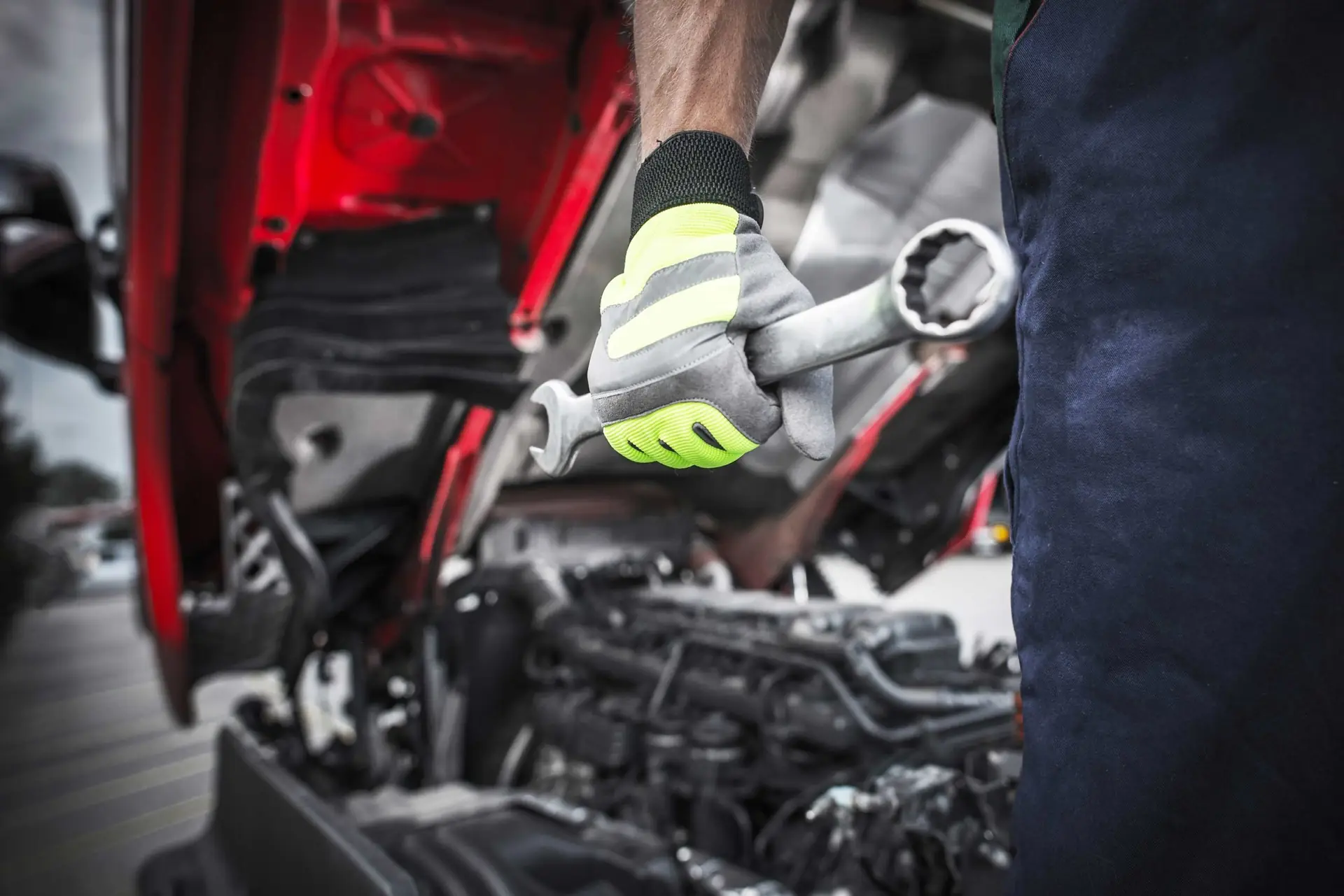Technician with spanner inside a truck engine bay