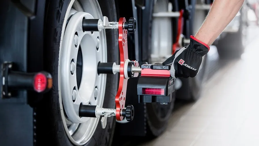 Technician fitting a Josam alignment head to a wheel